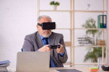 Eski işadamı ofiste sanal bardakların keyfini çıkarıyor.