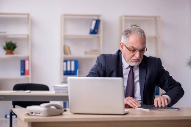 Ofiste çalışan eski bir işadamı.