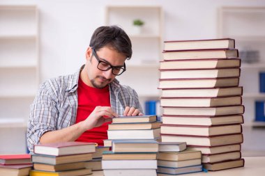 Genç bir öğrenci ve sınıfta çok fazla kitap var.