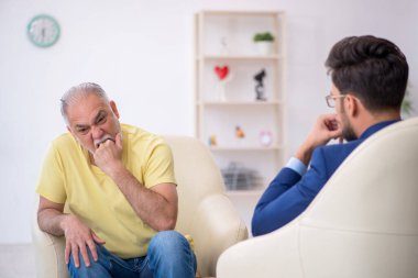 Yaşlı adam genç psikoterapisti ziyaret ediyor.