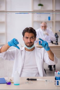 Laboratuvarda çalışan iki kimyager.