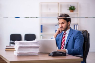 Genç işadamı ve işyerinde çok fazla iş var.