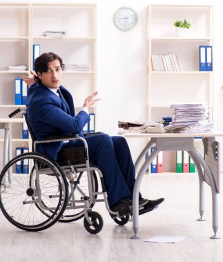 Ofiste çalışan tekerlekli sandalyedeki genç adam.