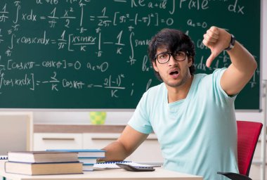 Tahtanın önündeki genç erkek matematikçi.