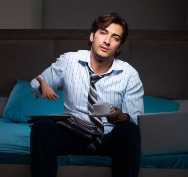 Yorgun işadamı gece fazla mesai yapıyor.