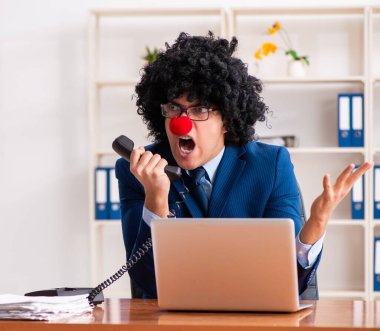 Ofiste çalışan genç palyaço işadamı.