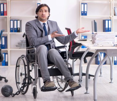 Ofiste çalışan tekerlekli sandalyedeki genç ve yakışıklı eleman.