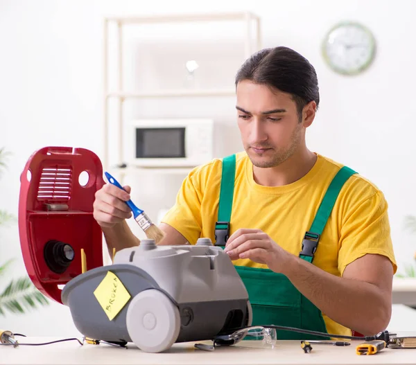 The man repairman repairing vacuum cleaner