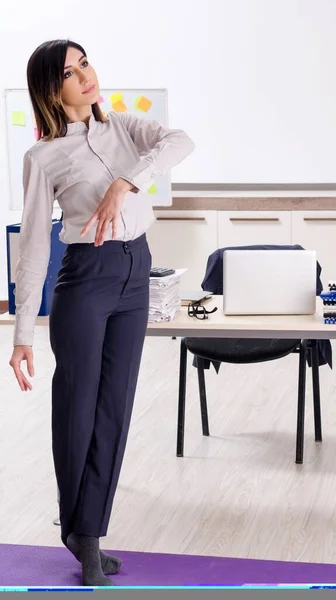 Young Female Employee Doing Exercises Workplace — Foto Stock