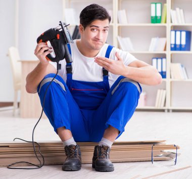 Zemin kaplamalarında çalışan genç işçi.