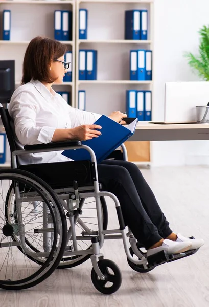 The female employee in wheel-chair at the office