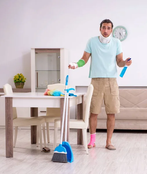 The young injured man cleaning the house