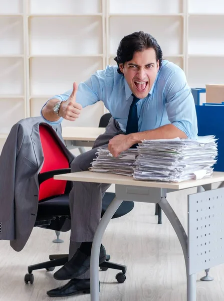 The young man employee with boxes in the office