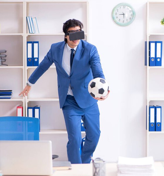 The young handsome businessman playing soccer with virtual glasses