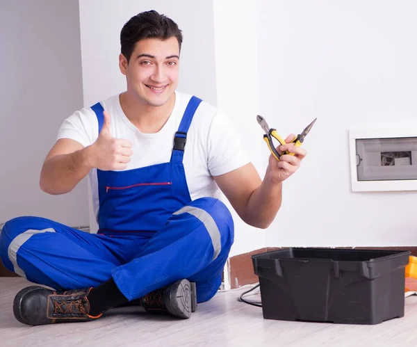 The young electrician working on socket at home