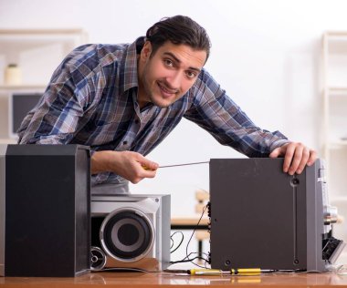 Genç mühendis müzik yüksek kurgu sistemini tamir ediyor.