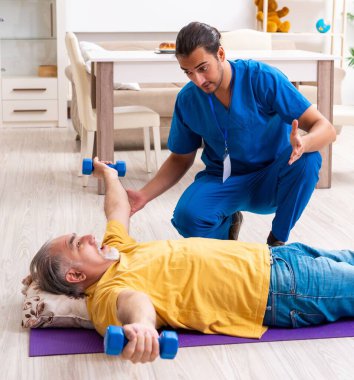 Genç erkek doktor eski hastayı ziyaret ediyor.