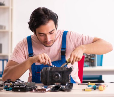 Genç erkek müteahhit bilgisayarı tamir ediyor.