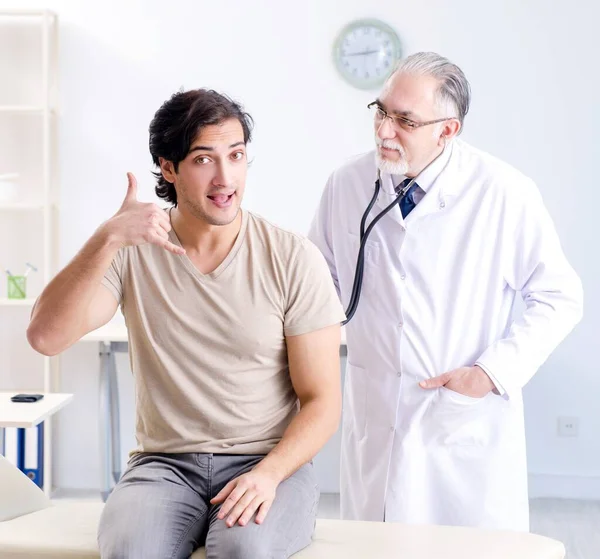 Young Male Patient Visiting Old Doctor — Stockfoto