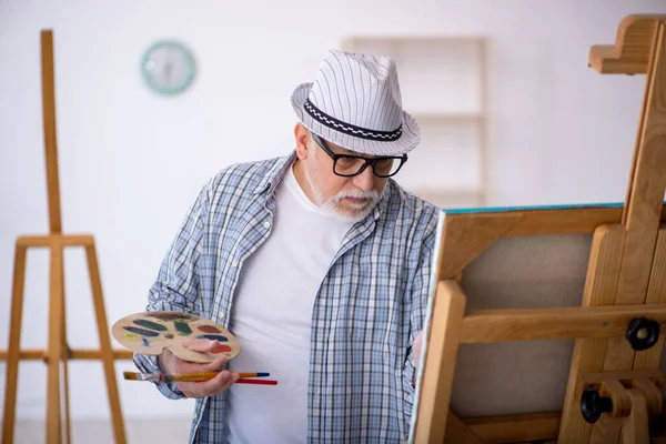 Aged man enjoying painting at home