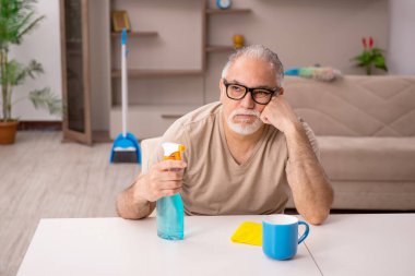 Evde ev işi yapan yaşlı bir adam.