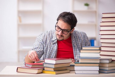 Genç bir öğrenci ve sınıfta çok fazla kitap var.