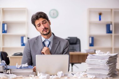 Genç bir çalışan ve ofiste çok fazla iş var.