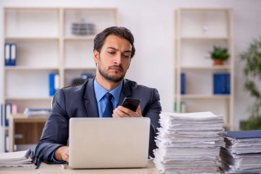 Genç işadamı ve ofiste çok fazla iş var.