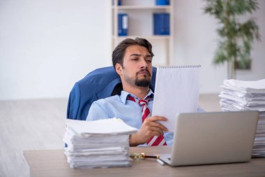 Genç işadamı ve ofiste çok fazla iş var.