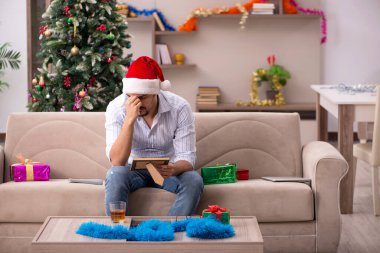 Genç adam yeni yılı evde yalnız kutluyor.