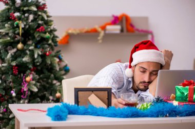 Genç adam yeni yılı evde yalnız kutluyor.