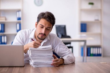 Genç işadamı ve ofiste çok fazla iş var.