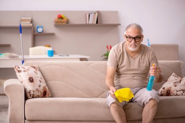 Evde ev işi yapan yaşlı bir adam.