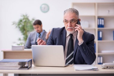 İki erkek çalışan işyerinde çalışıyor.