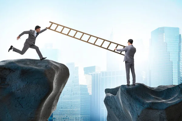 Business people helping to go over the chasm