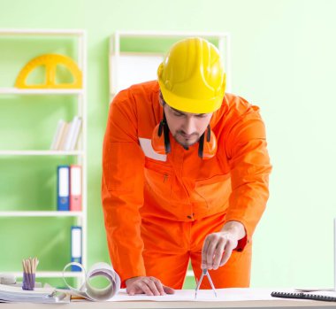 İnşaat denetçisi ofiste yeni bir proje planlıyor