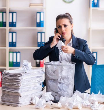 İş kadını bir sürü kağıtla yeni fikirleri reddediyor.