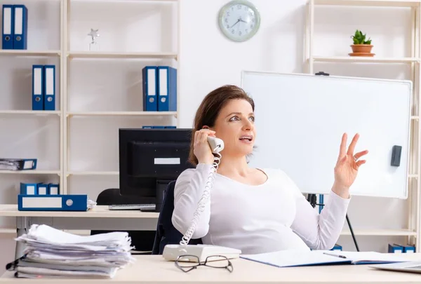 The experienced female employee working in the office