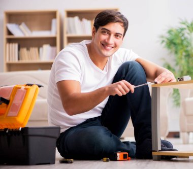 Evdeki rafları monte eden adam.
