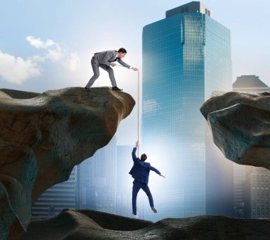 İş adamı, iş arkadaşına iple yardım ediyor.