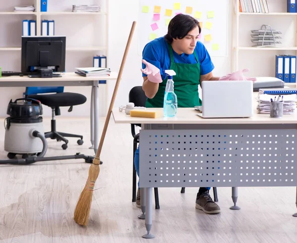 The male handsome professional cleaner working in the office