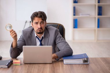 Genç işadamı işyerinde oturuyor.