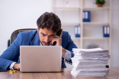 Genç işadamı ve işyerinde çok fazla iş var.