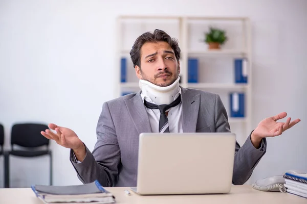 Young businessman employee after car accident working in the office