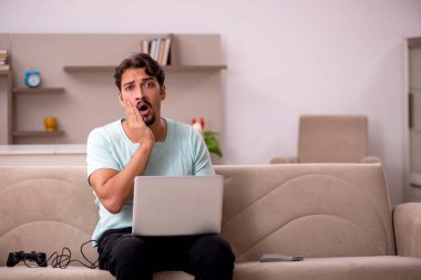 Evde oyun oynayan genç bir erkek öğrenci.