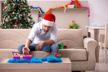 Genç adam yeni yılı evde yalnız kutluyor.