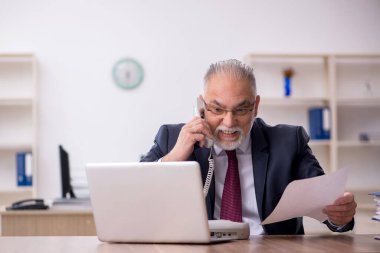 Ofiste çalışan eski bir işadamı.