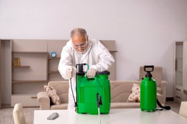 Yaşlı müteahhit evde haşere kontrolü yapıyor.