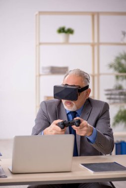 Eski işadamı ofiste sanal bardakların keyfini çıkarıyor.