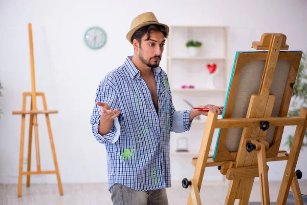 Young man enjoying painting at home